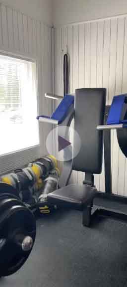 A well-equipped gym room with a bench and weights, perfect for various fitness routines and strength training.